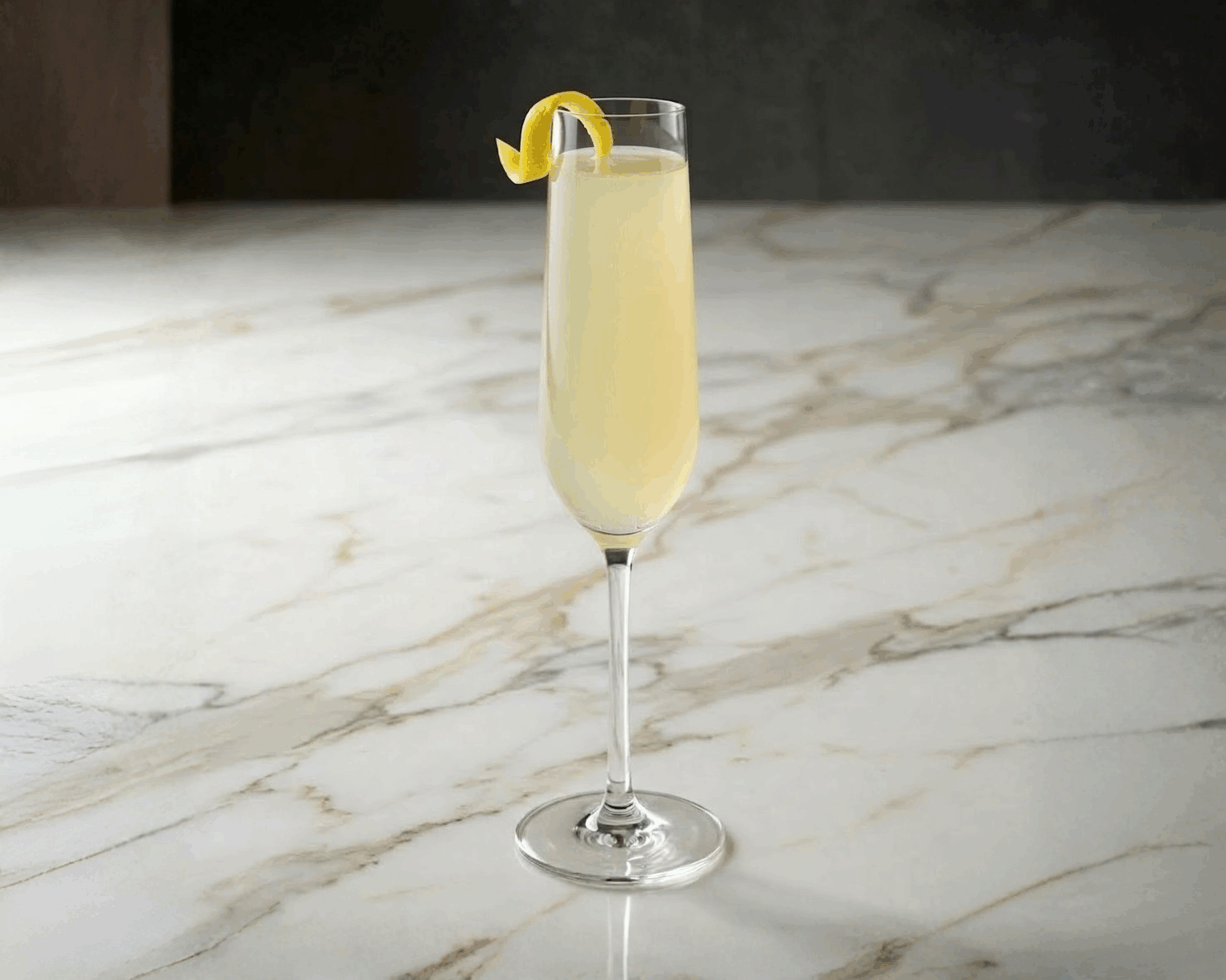 French 75 cocktail in a champagne flute with lemon twist