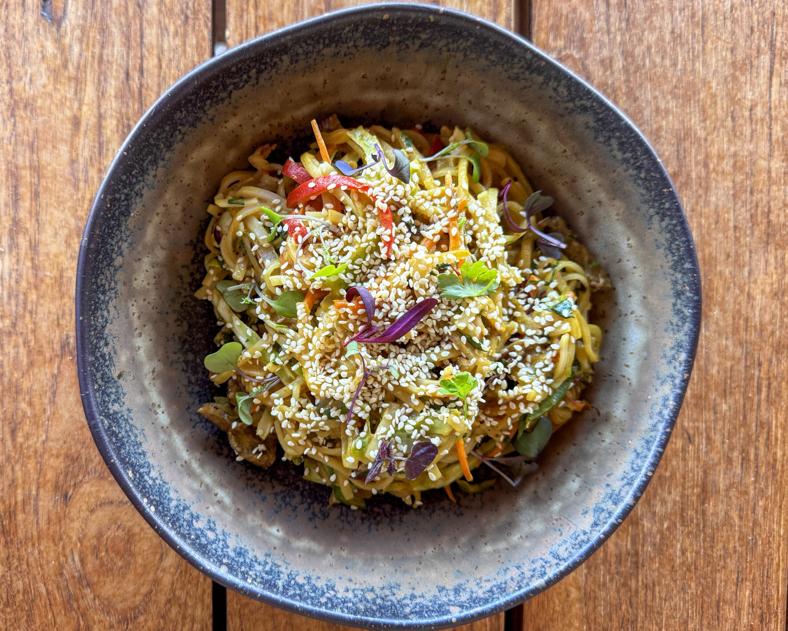 Peanut rice noodles with cabbage, carrots, jalapeños, cilantro, and sesame seeds.